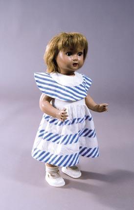 158 80. Muñeca Mariquita Pérez. Muñeca de cartón con vestido de paseo de algodón blanco con adornos de bieses con rayas azules y blancas.