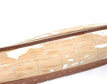 Recorta el extremo de popa de la tira de madera para que quede alineada con la falsa quilla.