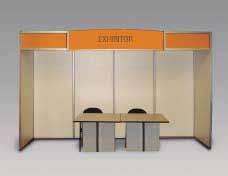 Plano de distribución La participación Standard incluye: Área Alfombrada. Paneles Laterales y Posterior. Punto de luz (220 volts, 60 Hz). Letrero, escritorio y 3 sillas. Librero.