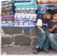 Los padres de estos niños venden mantas en el mercado en Sololá, Guatemala. Los niños ayudan de vez en cuando pero ahora les ha captado el interés el móvil.