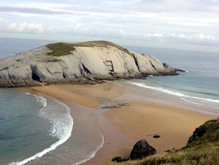 Tómbolo en Covachos (Cantabria) La refracción de las olas que provoca la presencia de un islote próximo a la costa, determina que entre ambos se produzca una formación sedimentaria llamada tómbolo.