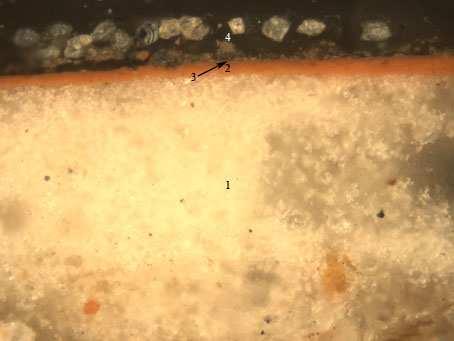 Figura III.2.2. Microfotografía obtenida al microscopio óptico con luz reflejada. Muestra: E45Q1 Aumentos: 200X Descripción: Corladura roja-dorada de la vuelta del manto.