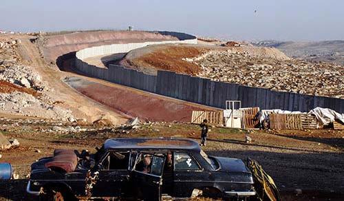 La construcción del Muro Conduciendo un rebaño de cabras a lo largo del Muro de Cisjordania, cerca del Monte de los Olivos, Jerusalén. Sin fecha. J.C. Tordai / UNRWA Foto Alegando principio de autodefensa debido a los ataques suicidas, el 23 de junio de 2002 Israel inicia la construcción del Muro.