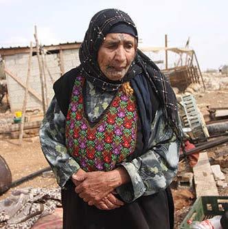 Una mujer de una comunidad beduina de pie en medio de las ruinas de su casa en Jabaa, Cisjordania.