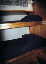 individuales. La dinette, situada a estribor y con asiento en forma de L, está equipada con una mesa de alas abatibles y se puede convertir en cama doble.