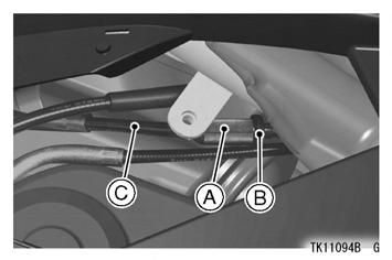 Afloje la contratuerca situada en el extremo inferior del cable del acelerador y gire la tuerca de ajuste completamente hacia dentro de manera que el puño del acelerador disponga de abundante holgura.