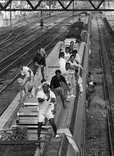 Pasajeros viajan ilegalmente en un tren metropolitano de Río de Janeiro, realizando una práctica que llaman surf. La fotografía fue tomada el 5 de diciembre de 1988.