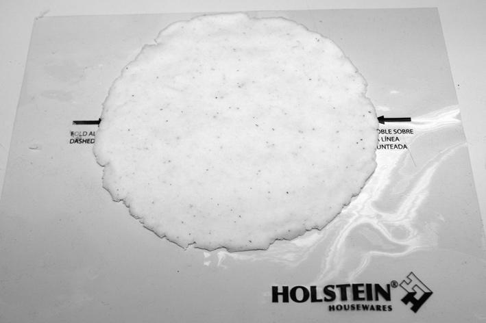 (Ver foto 8 y 9) 5. Coloque el queso en el centro del circulo de la masa. (Ver foto 10) 6. Doble el molde. (Ver foto 11) 7. Selle los bordes usando sus dedos.