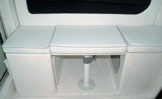 La base del asiento sirve de gran cofre de estiba o bien de alojamiento del frigorífico de 49 litros que se ofrece como opción. A popa del asiento se ha fijado un portavasos doble.