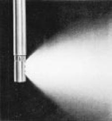 5 a 100 bar) por encima de la presión de vapor de agua para generar sprays cónicos de película fina y que se inyectan en el flujo de vapor de agua a través de una serie de boquillas atomizadoras de