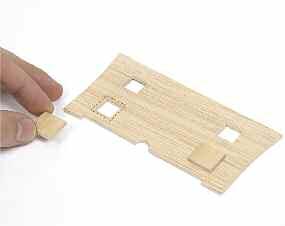 Pon pegamento de secado rápido en los extremos de los dos cuadrados y colócalos sobre las aperturas