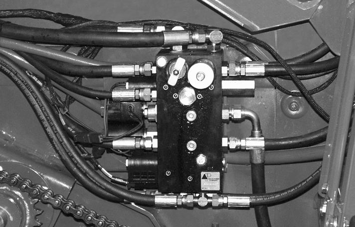 FIG. : Abra la válvula de alivio de presión () para liberar la tensión en las correas de formación. Consulte Alivio de tensión en la correa de formación en la sección de Lubricación y mantenimiento.