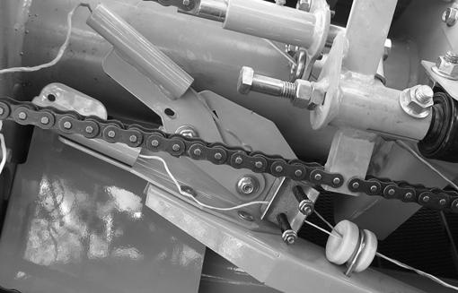 Compruebe el ajuste del resorte del tensor en los brazos de cordel realizando lo siguiente: Mueva el brazo de cordel hacia el centro de la máquina. Consulte Modo manual en la sección de Operación.