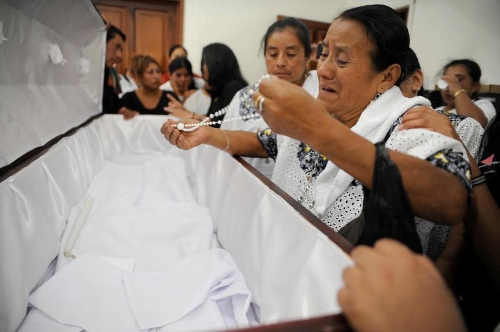 María Luisa Col una mujer q`eqchí llora en el féretro que contiene algunos restos óseos de su esposo que fue detenido ilegalmente por el Ejército el 13 de Enero de