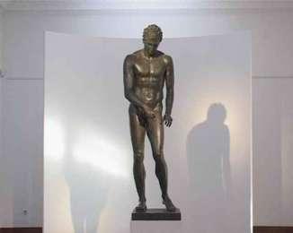 Strigil y los griegos lo llamaban Ksistro. En español a la estatua se le denomina El Raspador.