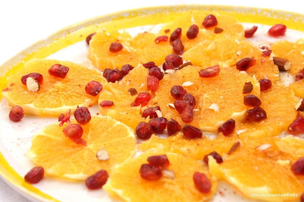 POSTRE DE FIESTA (María Teresa Esteban) Ingrediente: 4 naranjas 1 granada 12 nueces ¼ de litro de nata montada 100 gramos de miel caliente Pelar las naranjas, quitar toda la pulpa que las cubre.