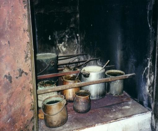 72 L'armari - estufa de les coles amb la fornal que s alimentava de llenya des de l'exterior i els pots de les coles diverses a l'interior Una escala portava al pis superior on hi havia el magatzem