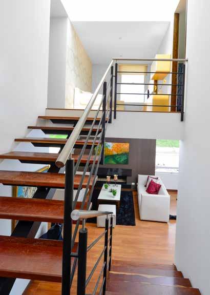 Zona de circulación En el centro geométrico de la vivienda se localizan las escaleras de madera que parecen flotar en el ambiente.