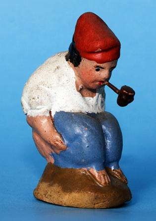 Caganer noucentista català de pessebre amb pantalons i fumant en pipa, fabricat pel figuraire Llobet (Barcelona). 302-305). Figura 14.