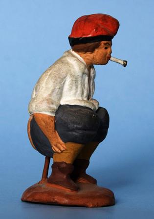 Caganer noucentista català de pessebre amb calces curtes i mitges, fumant un cigarret, fabricat pels germans Josep i Ramon Vidal (Barcelona). Figura 14.