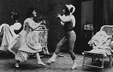 Hand-colored footage that represents the dance of a female harlequin with a Pierrette, the female version of the sad clown.