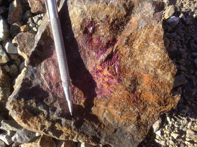 En esta labor se obtuvo una muestra desde material de desmonte de rocas de vetas de cuarzo-turmalina, biotita (cloritizada), crisocola, oxidados verdes de cobre, óxidos de hierro y óxidos de