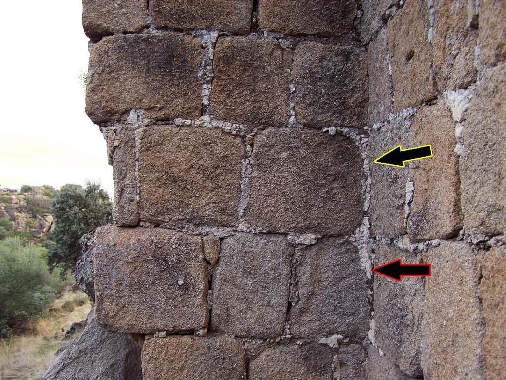 27 I) En esta imagen de la T5 de la muralla de la madīna observamos en la flecha con trazo rojo, un sillar en el que se evidencian marcas de pico y en el que señala la amarilla, uno con marcas de un