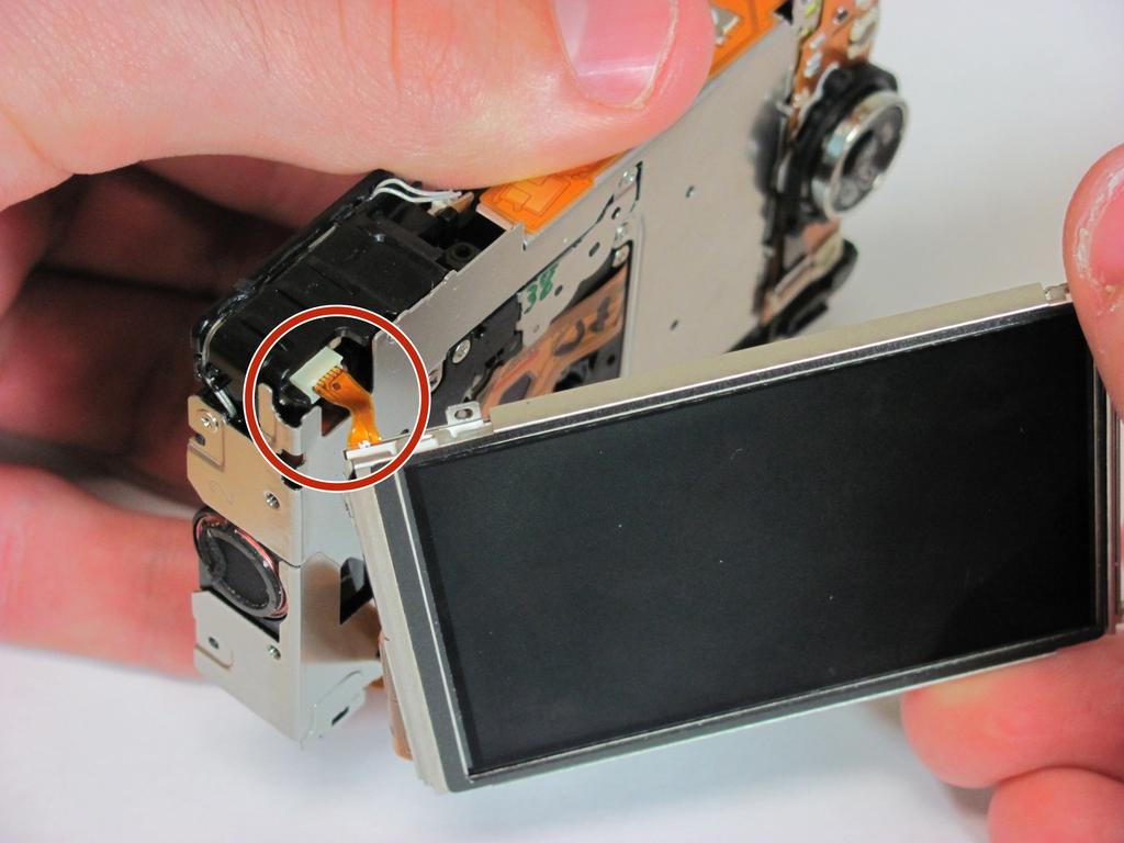 Paso 8 Desliza la pantalla LCD a la izquierda de la cámara y luego tirar suavemente la pantalla LCD lejos de la cámara. Nota: Mantenga la pantalla a la carcasa.